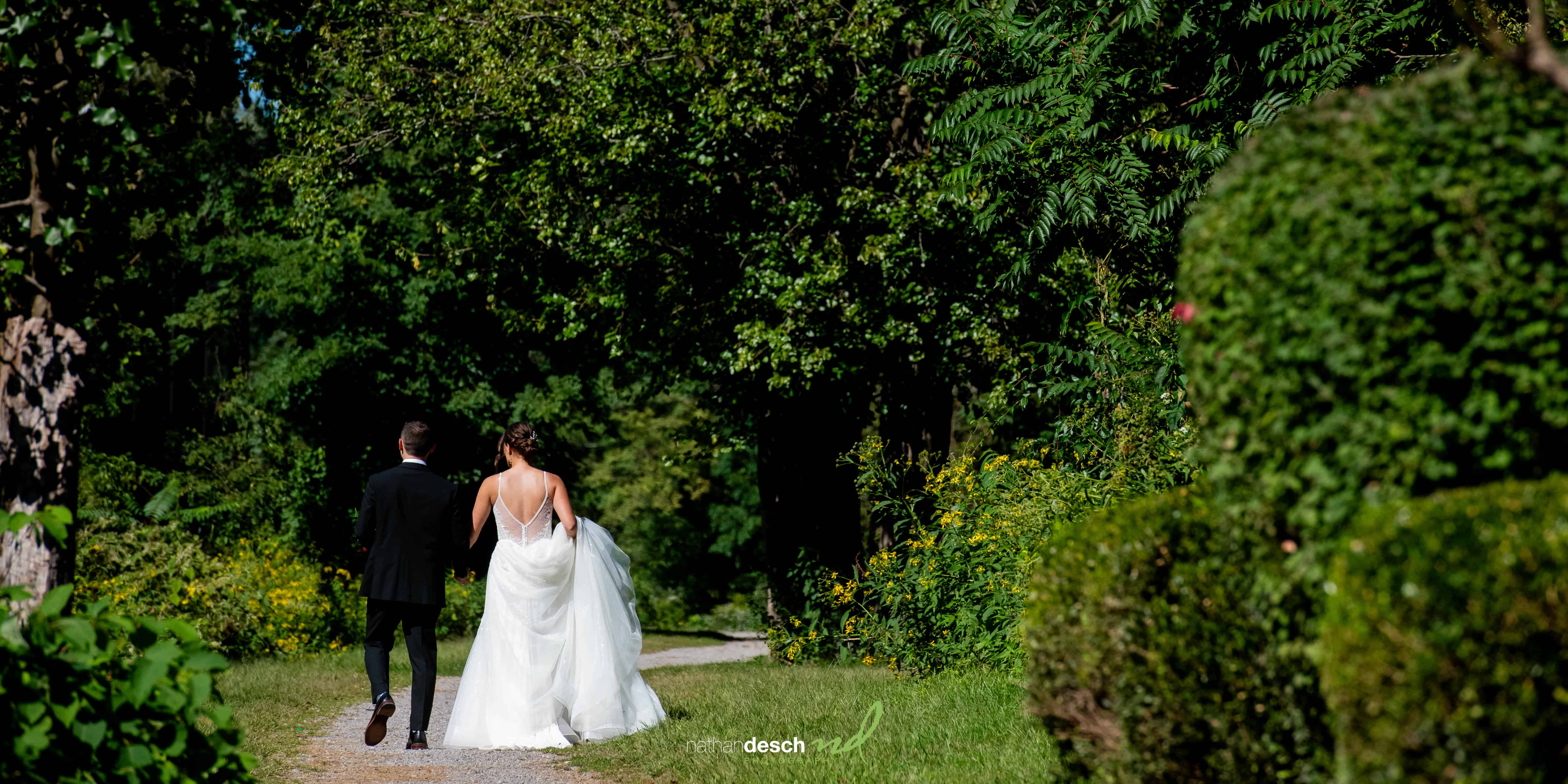 Bride and groom walking on towpath at river house at odettes