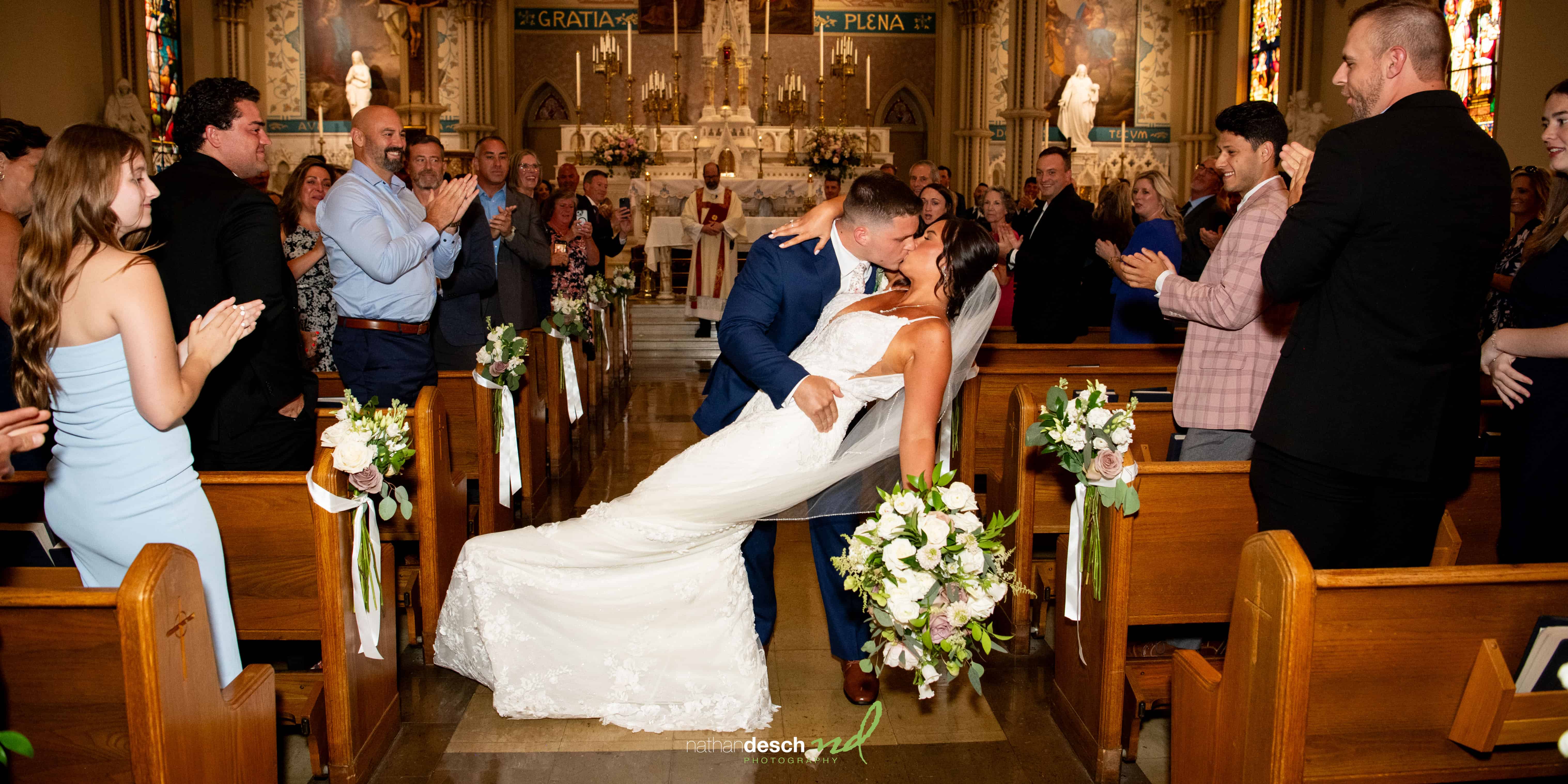 Bride and groom share kiss coming back up the aisle