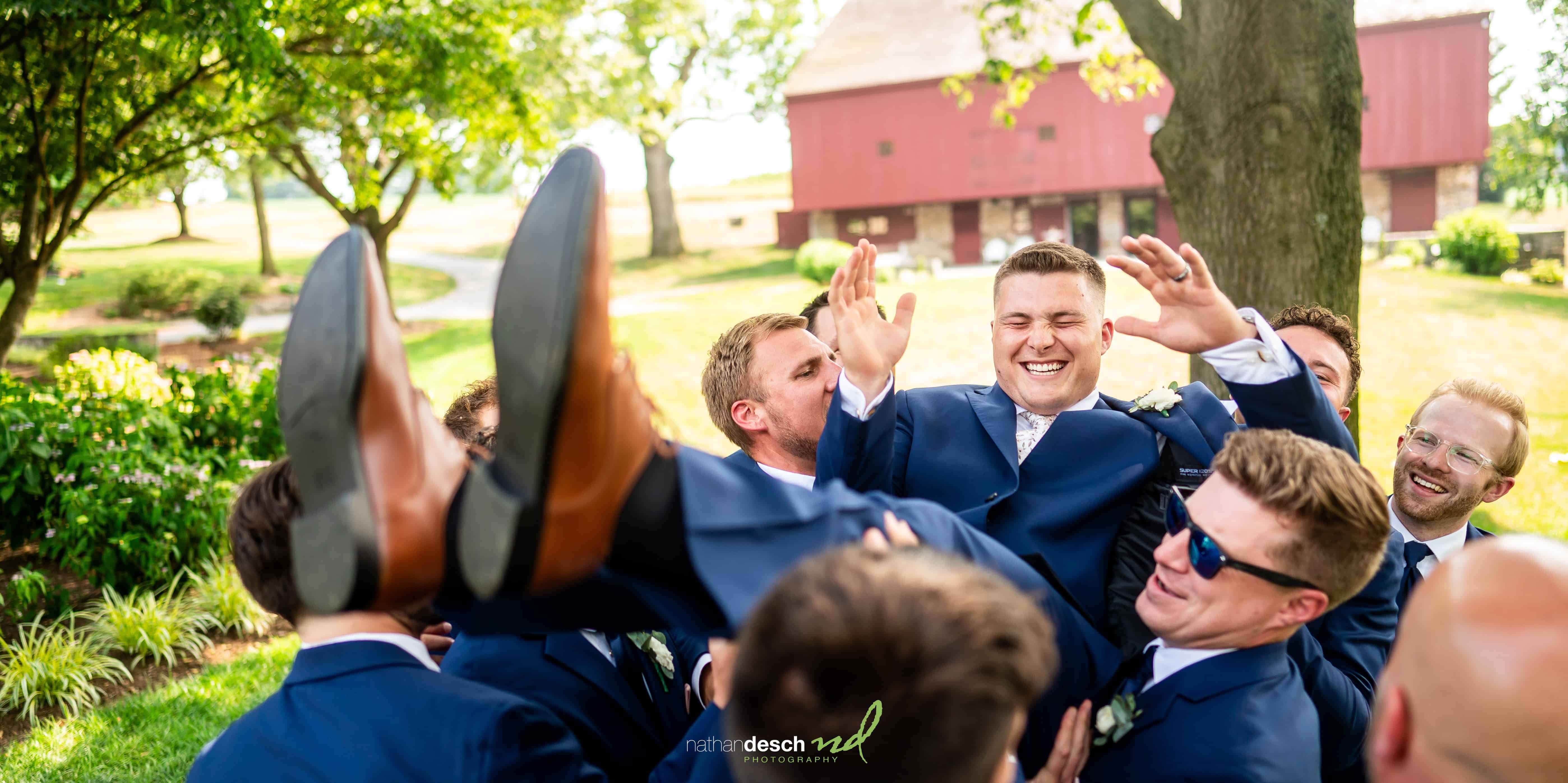 groomsmen lifting groom