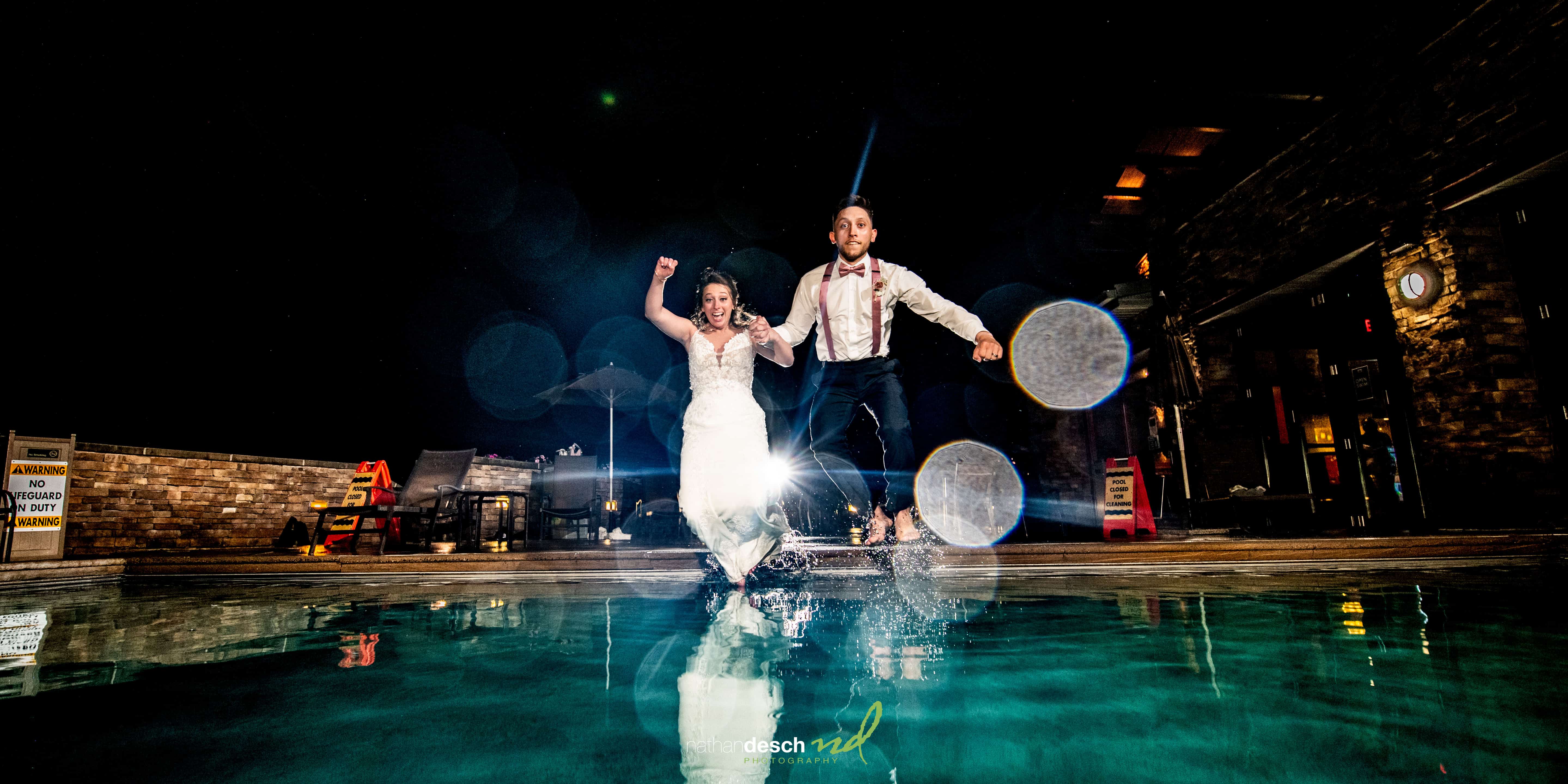 bride and groom jumping into pool at bear creek